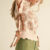 Woman wearing a patterned sweater with a tie detail on a beige background